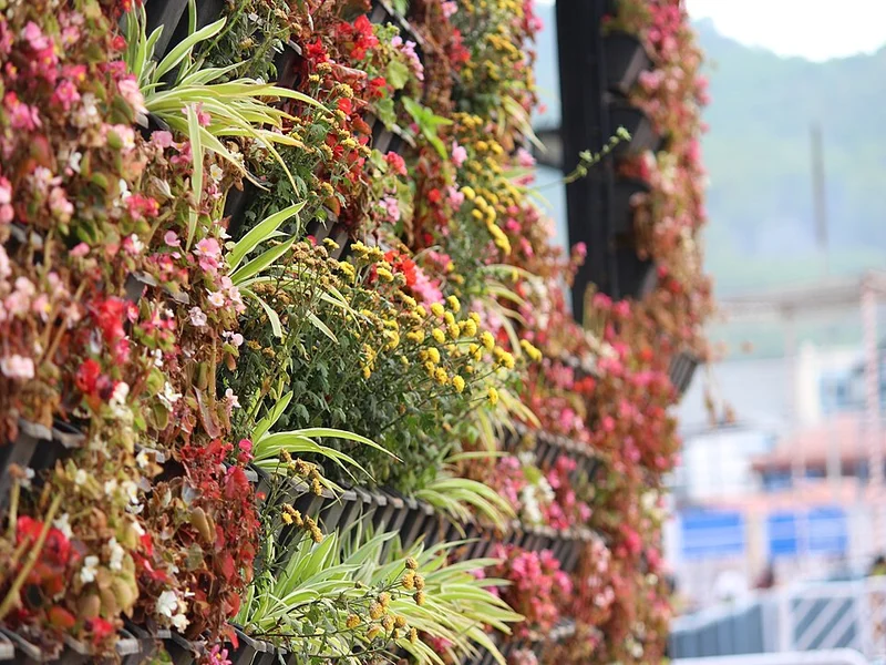 Jardineras verticales con lechugas y hierbas en una pared exterior
